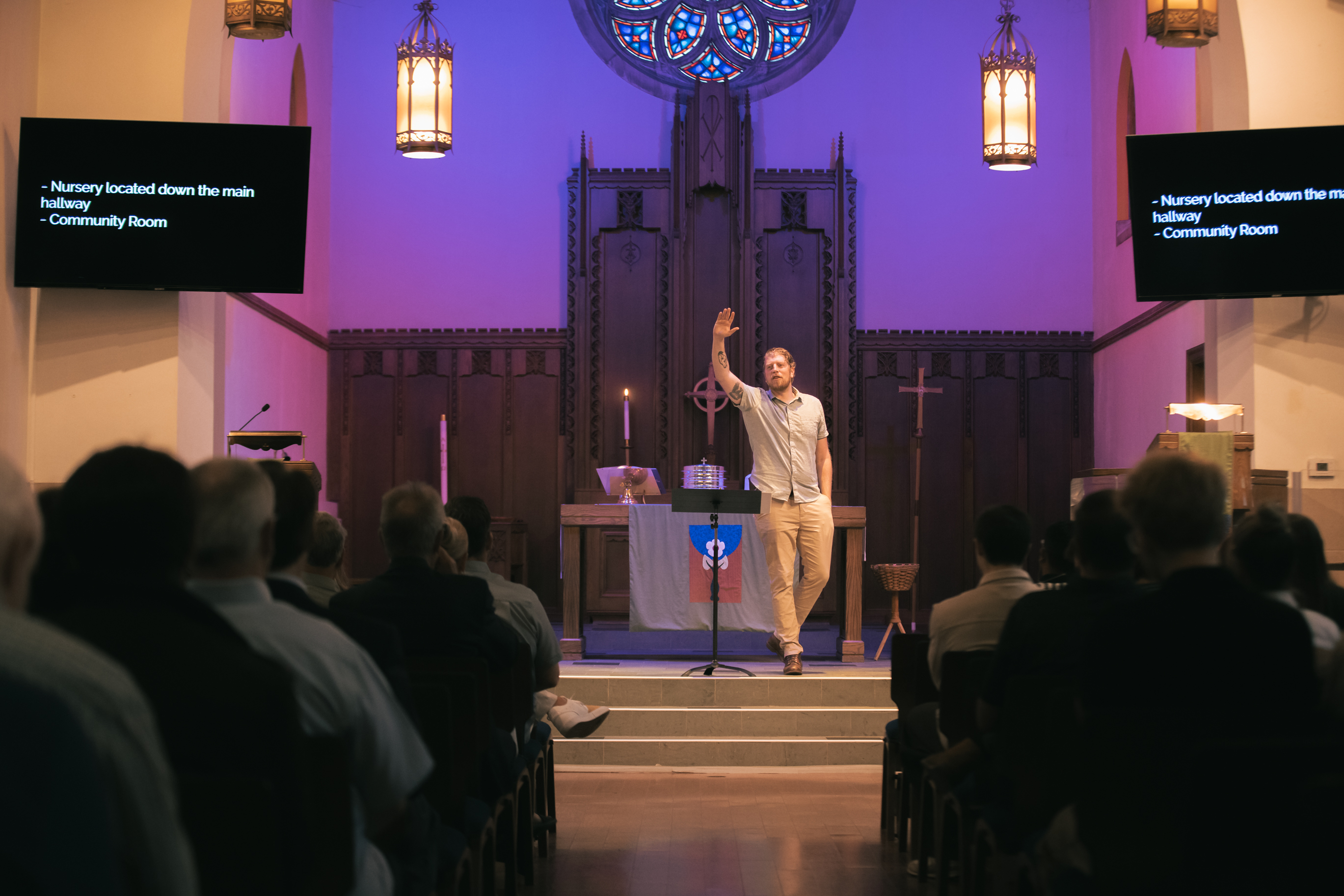 Pastor mid-sermon with the congregation and rose window